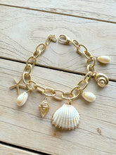 Load image into Gallery viewer, Gold charm bracelet with ocean-themed charms including shells and starfish