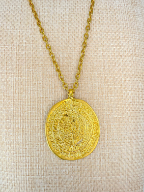 Gold Aztec calendar medallion necklace on display stand