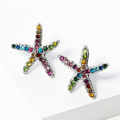 Starfish stud earrings with multicolor crystals on white plate with gold rim