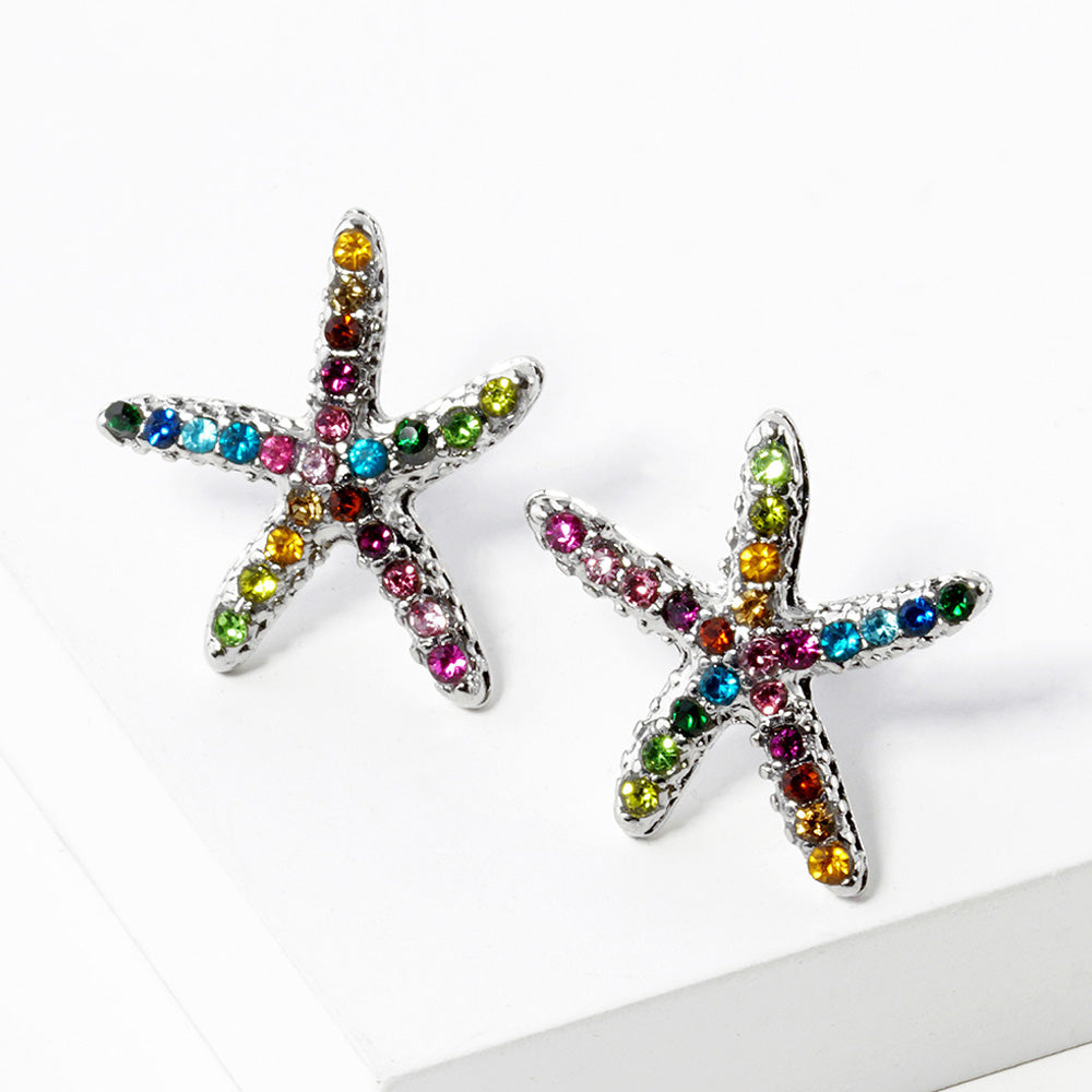 Starfish stud earrings with multicolor crystals on white plate with gold rim